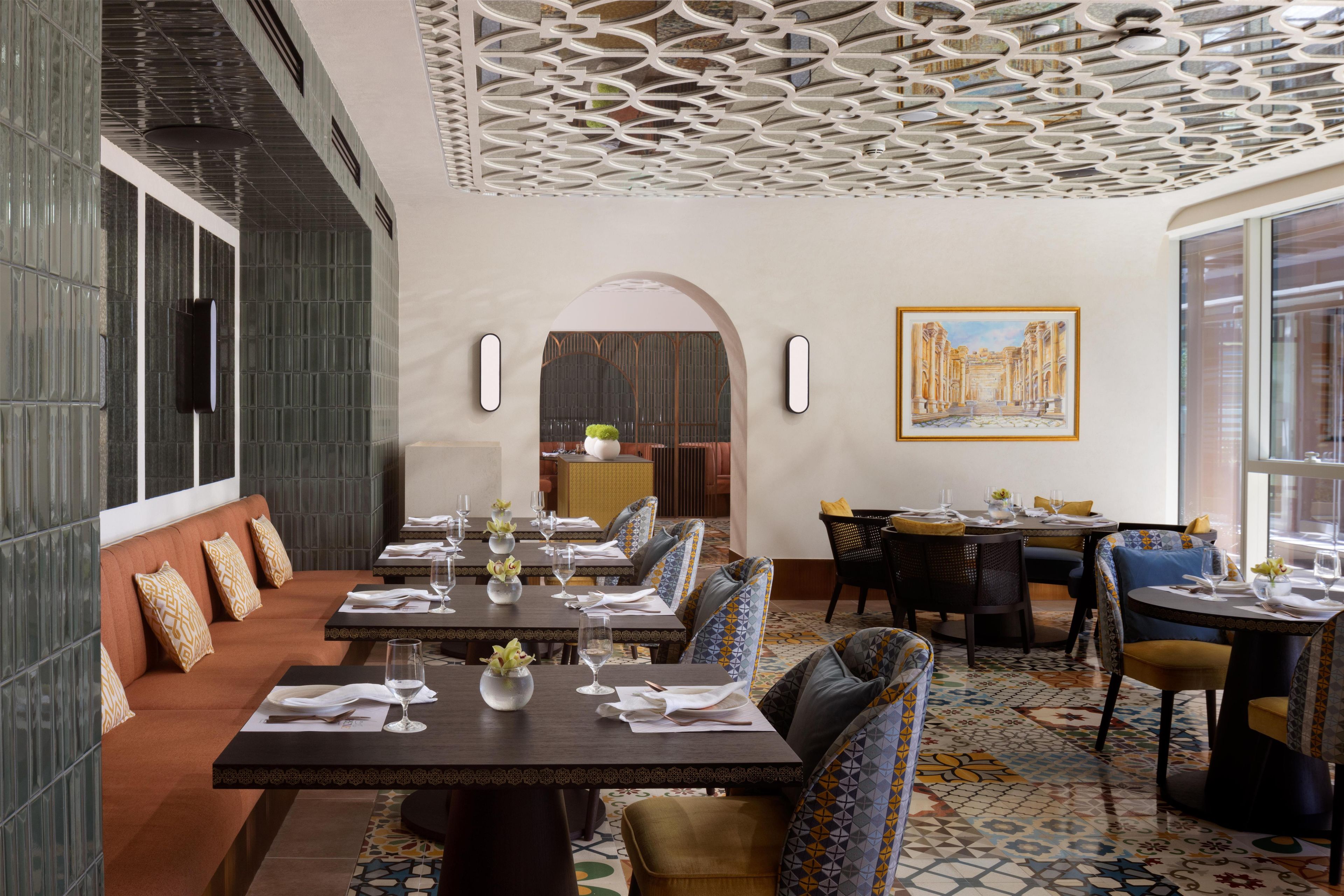 A dining area with long tables, chairs, and a patterned floor.