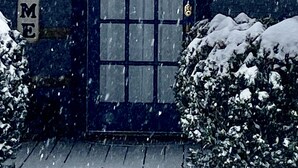 A building with a dark blue door, a 'WELCOME' sign, and a 'Creekside Cabin' sign.