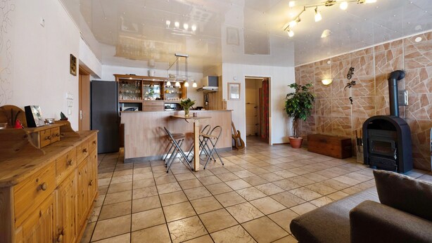 A spacious living area with a kitchen, a fireplace, and a dining area. - Vacation Apartment "Wiesental" with Wi-Fi, Wood-Burning Stove & Shared Garden (Meisburg)