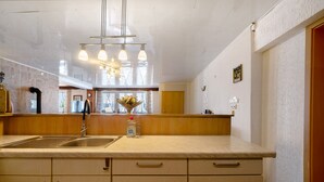 A kitchen with a sink, wooden cabinets, and a vase with flowers. - Vacation Apartment "Wiesental" with Wi-Fi, Wood-Burning Stove & Shared Garden (Meisburg)