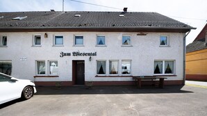 A two-story building with a sign reading 'Zum Wiesental' and a bench outside. - Vacation Apartment "Wiesental" with Wi-Fi, Wood-Burning Stove & Shared Garden (Meisburg)