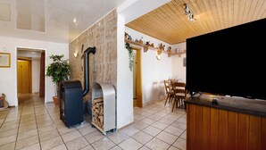 A modern interior with a fireplace, a television, and a dining area. - Vacation Apartment "Wiesental" with Wi-Fi, Wood-Burning Stove & Shared Garden (Meisburg)