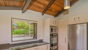 A modern kitchen with a built-in oven, microwave, and stainless steel refrigerator.