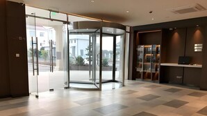 A hotel lobby with a revolving door, a reception desk, and a tiled floor. - Jinjiang Inn Select (Shanghai)