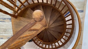 Una escalera en espiral de madera con barandilla y balaustres.