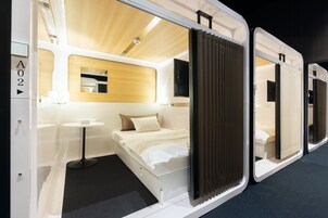 Une chambre d’hôtel moderne avec un lit, une table de chevet et une petite table ronde.