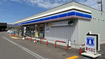 A Lawson station with a blue and white facade, a covered entrance, and a sign indicating it is a Lawson station.