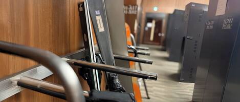 A row of lockers with metal bars and a wooden floor.