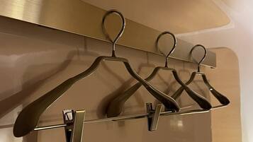 A wall-mounted coat rack with four metal hangers.