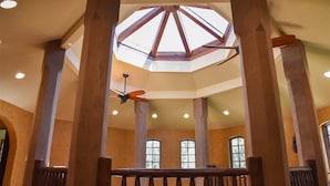 A spacious atrium with a high ceiling, large windows, and a central skylight.