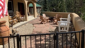 A patio area with outdoor seating, a flag, and a mountainous backdrop.