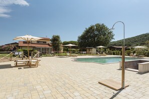 A pool area with a hot tub, lounge chairs, and umbrellas. - Agriturismo Terre di Castiglione (Castiglione della Pescaia)