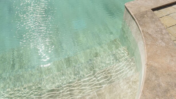A clear pool with visible water ripples and a stone edge. - Agriturismo Terre di Castiglione (Castiglione della Pescaia)