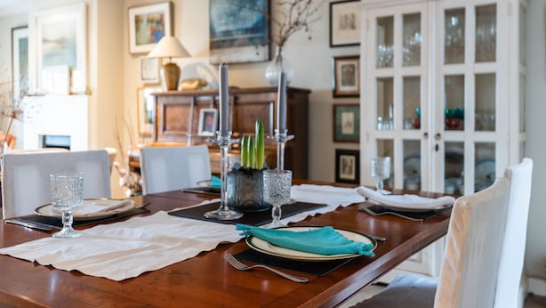 A dining table set with plates, glasses, and cutlery, surrounded by chairs. - A Hidden Mews (London)