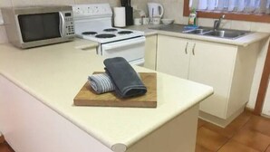 A kitchen with a microwave, stove, and sink.