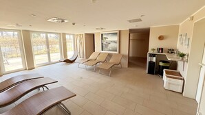 Una habitació àmplia amb un gran finestral, una zona de dinar i una zona d'estar amb cadires.