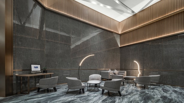 A modern interior with a high ceiling, recessed lighting, and a seating area with a round table and chairs. - Holiday Inn Express Nanchang Bayi Square by IHG (Nanchang)