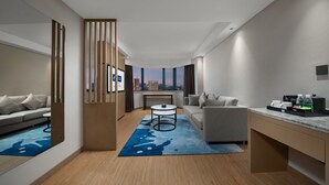 A modern hotel room with a city view, a sofa, a desk, and a coffee machine. - Holiday Inn Express Nanchang Bayi Square by IHG (Nanchang)
