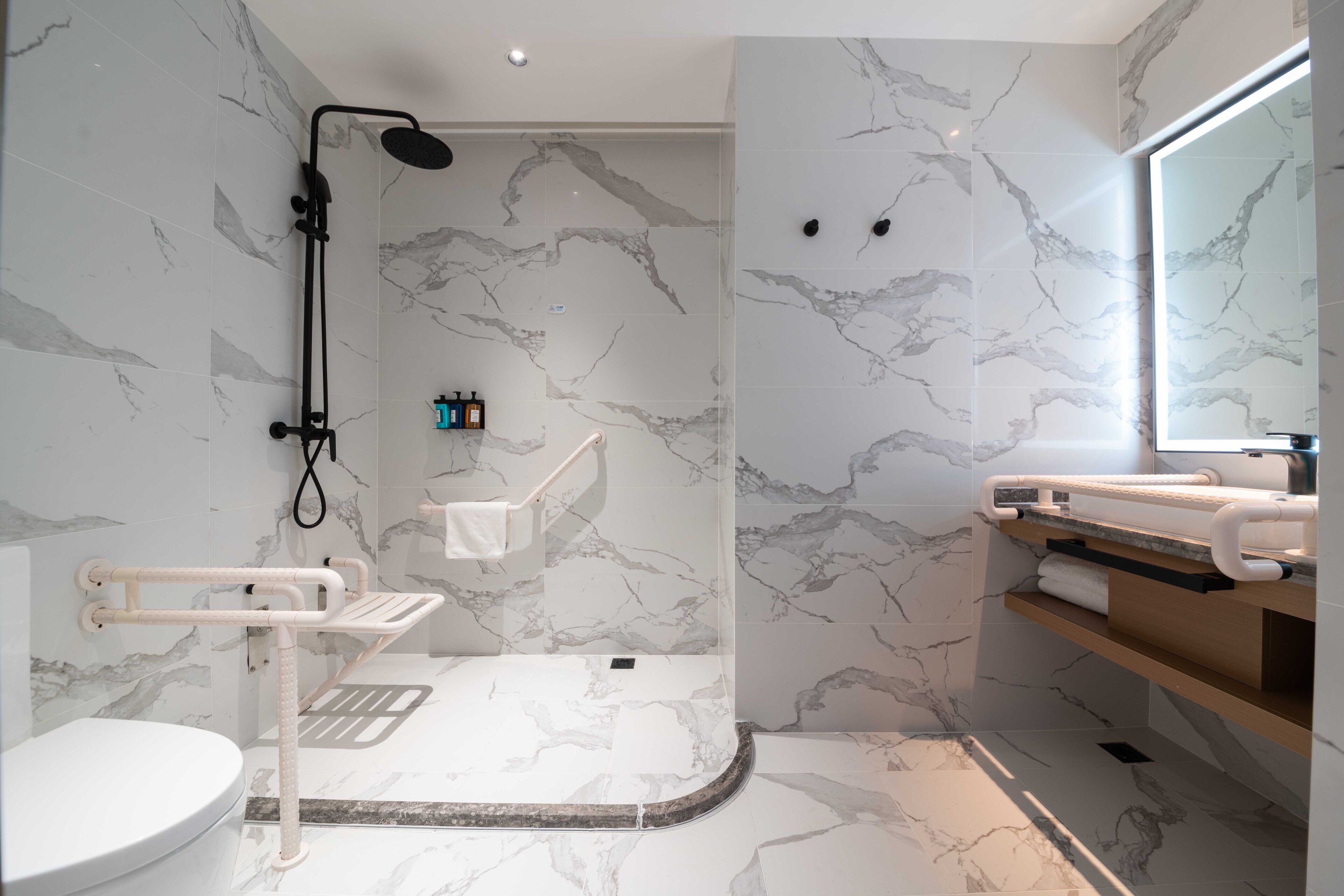 A modern bathroom with a shower, toilet, and vanity.