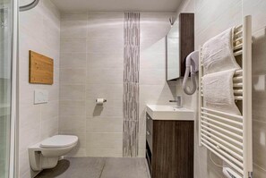 Regadera, secadora de cabello, toallas, papel de baño 