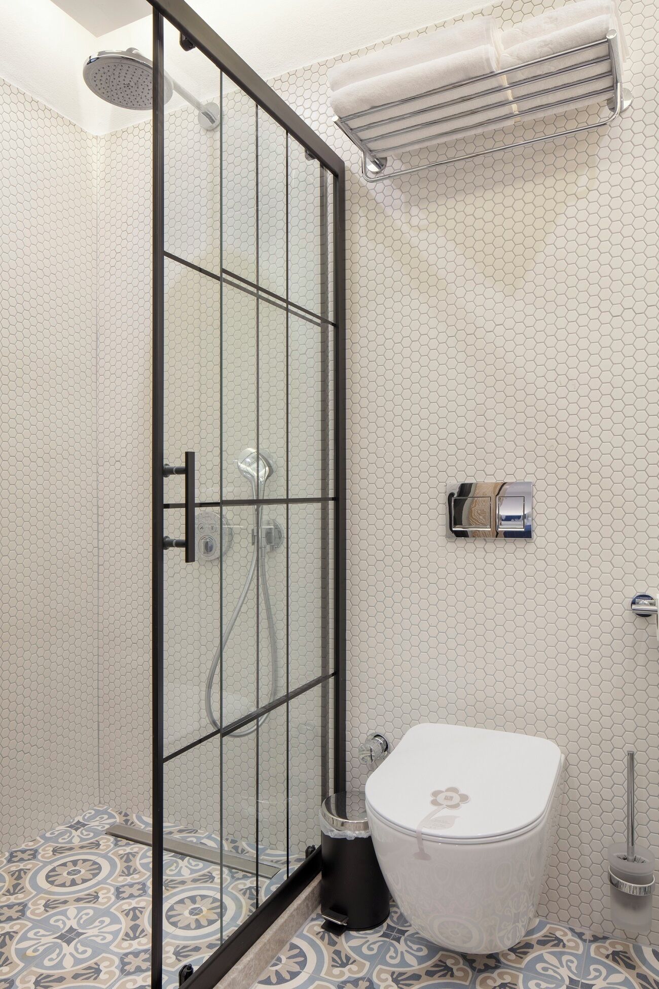 Un bany modern amb una dutxa de vidre, un vàter i un lavabo.