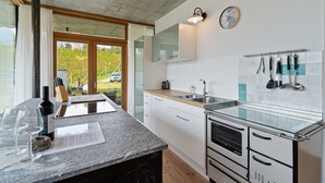 Una cucina moderna con un piano di lavoro in granito, elettrodomestici in acciaio inossidabile e un'ampia finestra che si affaccia sul verde.
