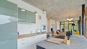 Una cucina moderna con un'ampia isola, mobili bianchi e vista sull'esterno.