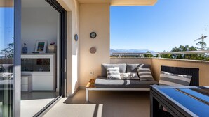 Ein Balkon mit einer Couch, einem Tisch und Blick auf die Berge.