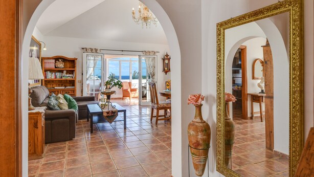 A spacious living room with a sofa, coffee table, and a bookshelf. - Villa "Rústica" close to the Beach with Sea and Mountain Views, Pool & Terraces (Matagorda)