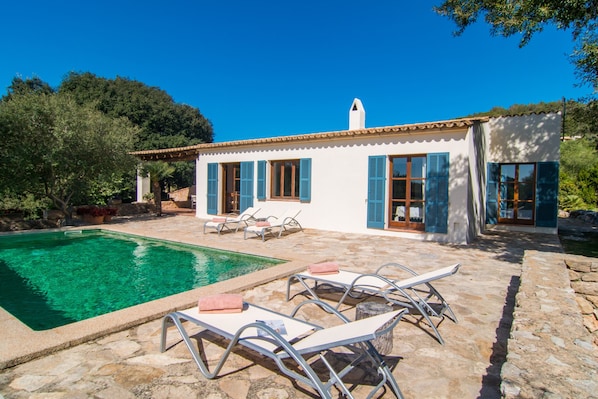 A poolside area with lounge chairs and a clear pool. - Beautiful Holiday Home “Finca Es Garballó” with Garden, Pool, Terraces & WiFi; Parking Available (Son Servera)