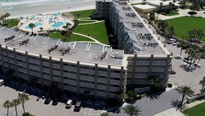 Un hôtel à plusieurs étages, doté d’une façade incurvée, d’un espace piscine sur le toit et d’un parking.