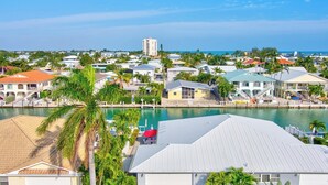 Un quartier résidentiel situé sur la côte, avec des maisons, un port de plaisance et une vue dégagée sur l’océan.