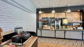 A kitchen area with a brick wall, a counter with various food items, and a stove.