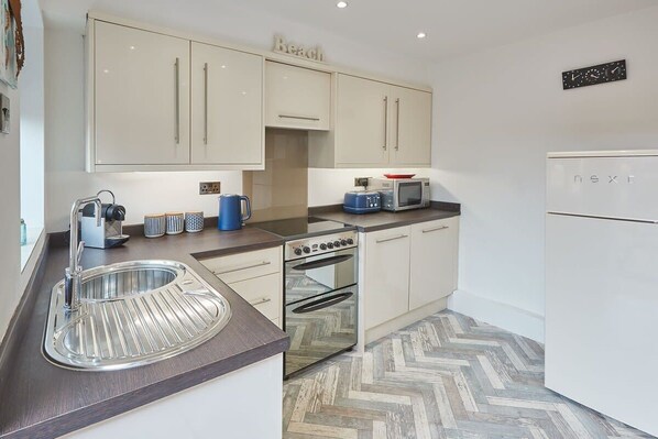 A modern kitchen with a built-in oven, a microwave, and a sink. - Host & Stay | The Cottage, Marske (Marske-by-the-Sea)