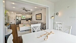 A modern living space with a dining area, kitchen, and a ceiling fan. - Siesta Key Resort, Private beach, pickle ball & tennis paradise. (Siesta Key)