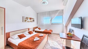 Habitació d'hotel amb dos llits, un escriptori amb televisió, un quadre i una finestra amb vistes.