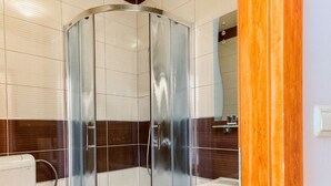 A modern bathroom with a glass-enclosed shower, a white toilet, and a sink. - ROOM WITH SEE VIEW FOR 2 (Podstrana)