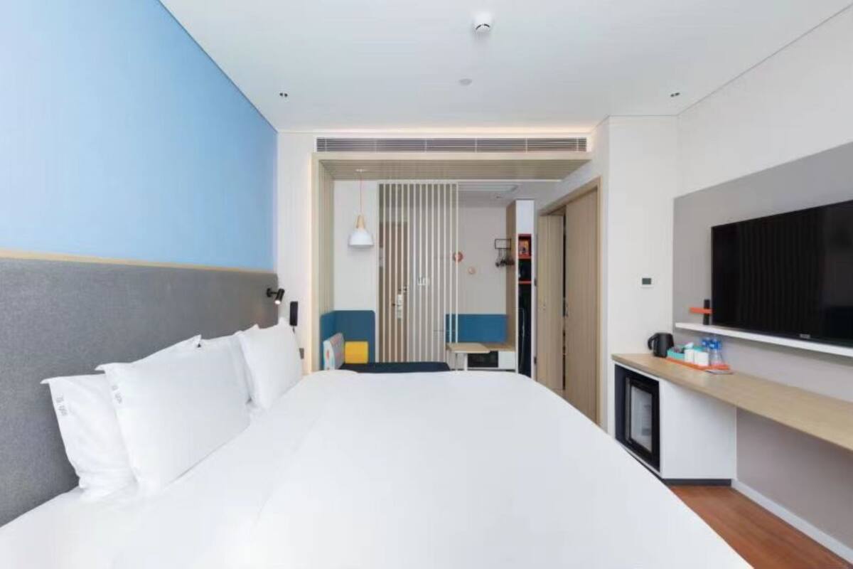 Une chambre d’hôtel équipée d’un lit, d’une télévision, d’un bureau et d’une armoire.