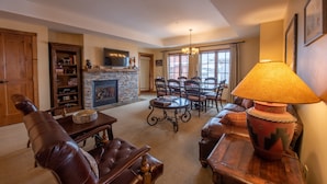 A cozy living room with a fireplace, leather furniture, and a dining area. - Large 3 Bedroom Bathroom In Mountaineer Square Condo - No Cleaning Fee! by RedAwning (Crested Butte)