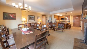 A spacious dining area with a large wooden table, multiple chairs, and a chandelier. - Large 3 Bedroom Bathroom In Mountaineer Square Condo - No Cleaning Fee! by RedAwning (Crested Butte)