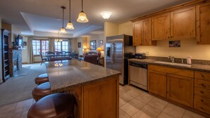 A spacious kitchen with a central island, wooden cabinets, stainless steel appliances, and pendant lighting. - Large 3 Bedroom Bathroom In Mountaineer Square Condo - No Cleaning Fee! by RedAwning (Crested Butte)