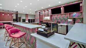 A modern kitchen with a bar area, equipped with a coffee machine and a dishwasher.