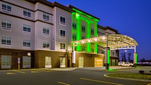 A Holiday Inn hotel with a covered entrance and a parking lot.