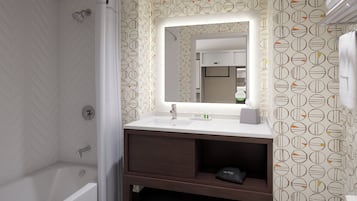 Ein Badezimmer mit Dusche, Waschbecken mit Spiegel und Handtuchhalter.
