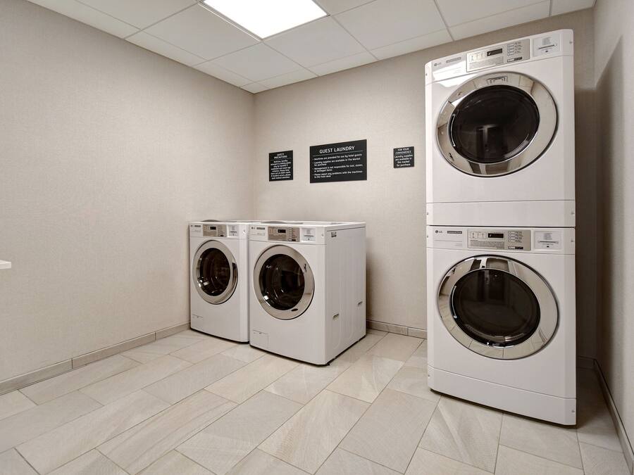 A laundry room with two front-loading washing machines and a sink.