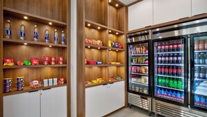 A snack and beverage area with wooden shelves and refrigerated cases.