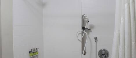 Una ducha con cabezal de ducha manual, grifo empotrado y manguera para ducha.