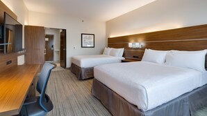 A hotel room with two beds, a desk, a chair, a TV, and a framed picture on the wall.