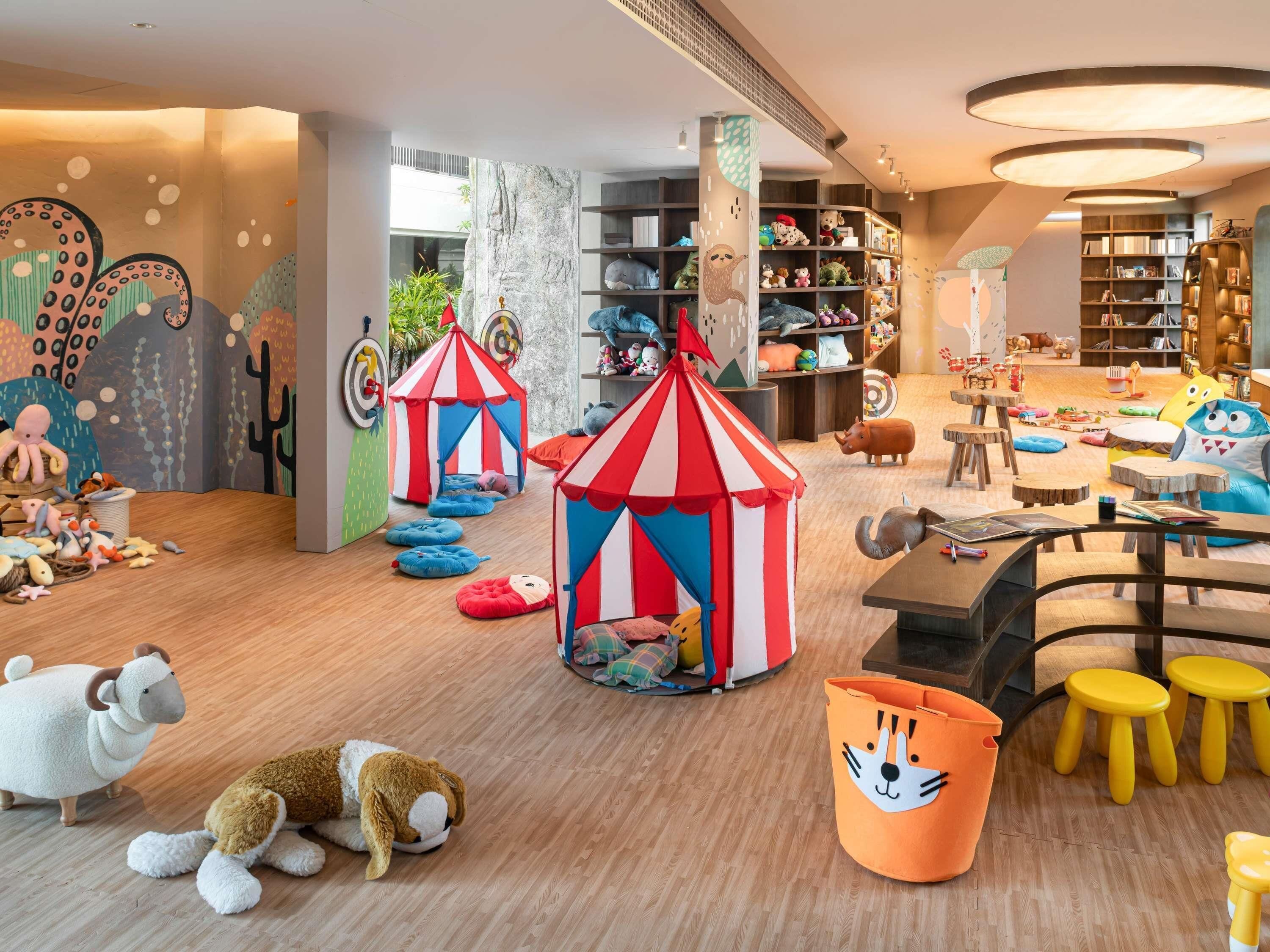 Un área de juegos infantiles con suelo de madera, coloridos saquitos y varios juguetes.