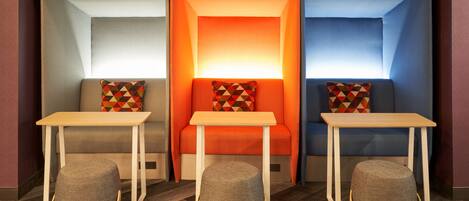 A room with three seating areas, each with a table and a cushion.